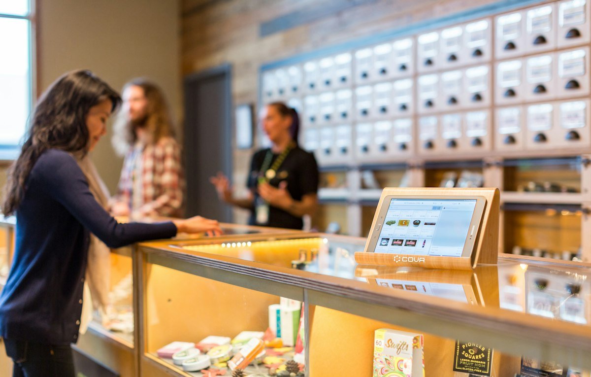 Budtender serving customers at the counter