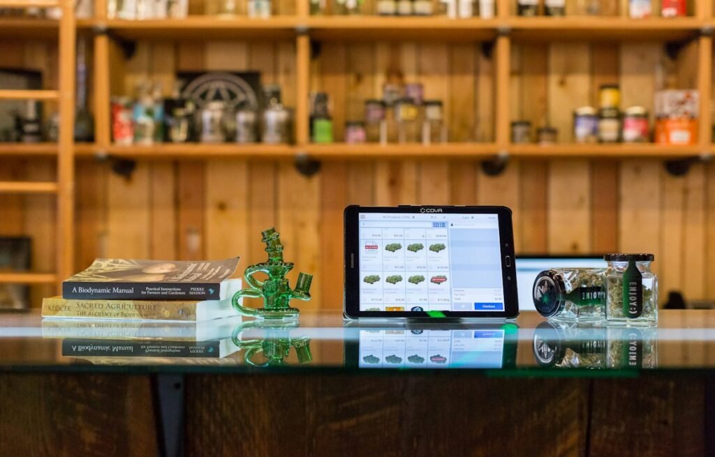 Glass jars of cannabis flowers stored on wooden shelves away from sunlight